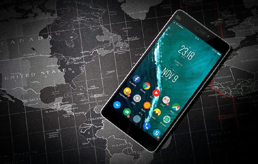 Android Handy mit West-Weltkarte im Hintergrund.